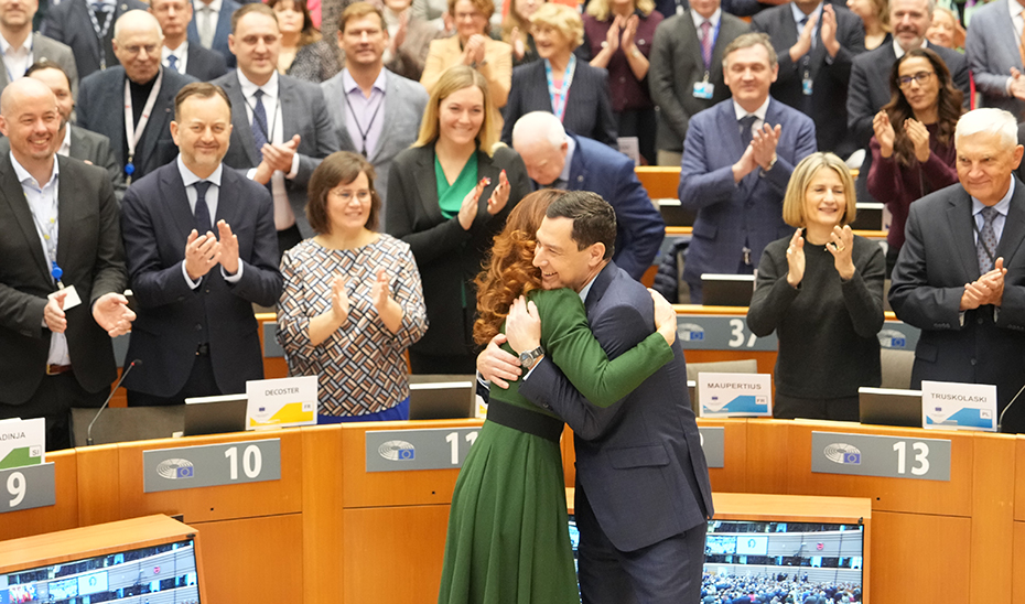 El presidente andaluz abraza a Kata Tutto, junto a la que presidirá conjuntamente el Comité Europeo de las Regiones.
